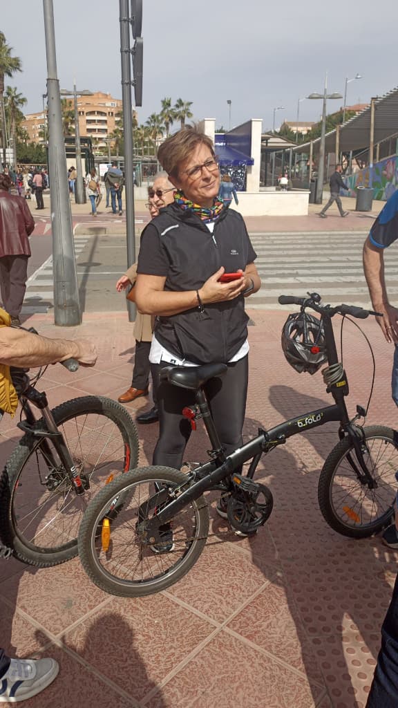 Adriana con indumentaria deportiva junto a una bicicleta en un carril bici