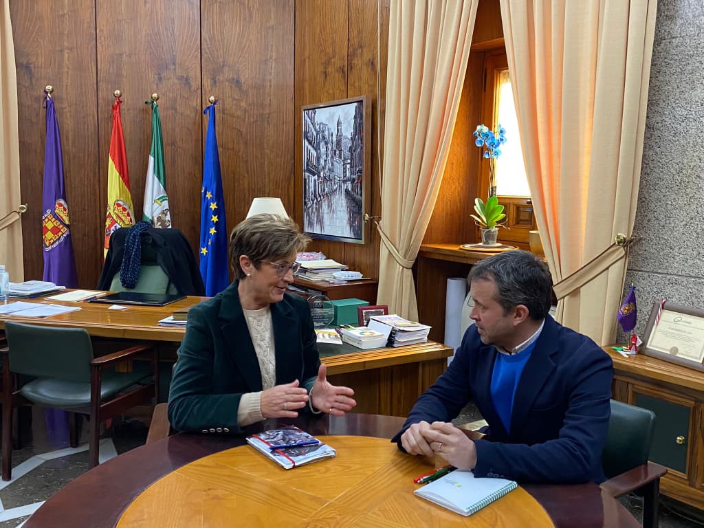 Adriana Valverde conversando con Julio Millán en su despacho.