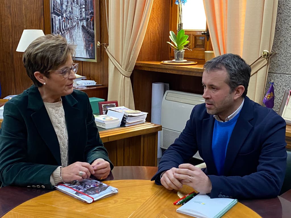 Adriana Valverde conversando con Julio Millán en su despacho.