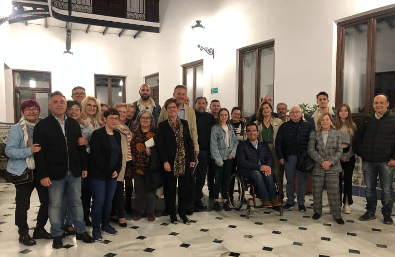 Grupo grande de personas asistentes a la mesa redonda de educación en el patio interior de el edificio.