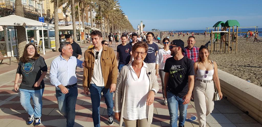 Adriana Valverde, candidata del PSOE a la Alcaldía de Almería, con un grupo de jóvenes en el paseo marítimo de la ciudad.