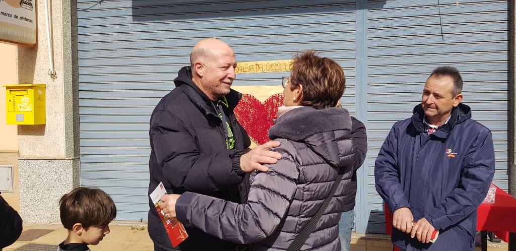 Adriana Valverde, junto a miembros de su equipo y vecinos y vecinas de El Alquián, ante una de las instalaciones de madera con motivos alusivos al amor para hacerse fotos que se repartieron por el barrio.