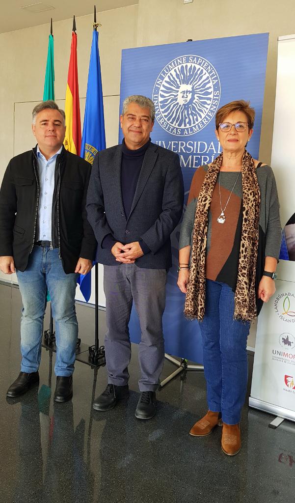 De izquierda a derecha, el concejal Antonio Ruano, Carmelo Rodríguez, rector de la Universidad de Almería y Adriana Valverde posan de pie sobre el logo del campus almeriense.